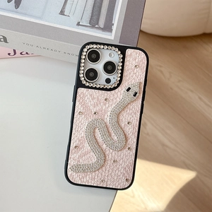 Close-up of pink snakeskin leather iPhone case with luxury rhinestone snake emblem
