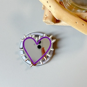 Detailed view of heart-shaped phone grip with purple border and mirror finish on gray base