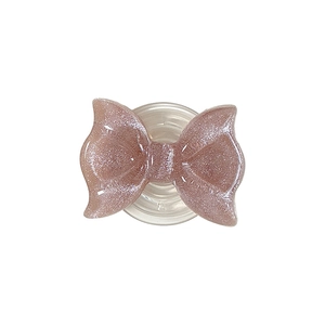 Pink glitter bow MagSafe phone grip with transparent collapsible socket on white background