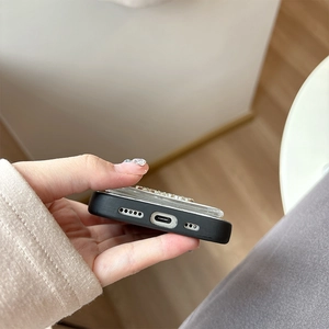Close-up of precise speaker and charging port cutouts on a black bow rhinestone phone case