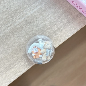 Detail of cute bear and 3D house inside round acrylic expandable phone socket grip