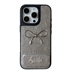 Silver wrinkled leather iPhone case with metal bow and Smile text on white background