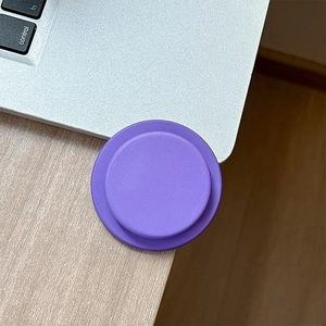 Close-up of matte purple magnetic phone socket on a laptop for desk setup use