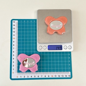Macro detail of butterfly phone grip on scales showing weight and 6x5cm dimensions
