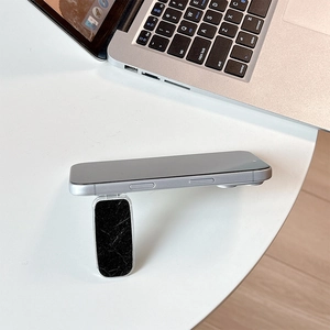 Close-up of a foldable phone stand with black marble texture support for desktop viewing