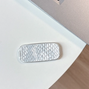 Macro view of white faux crocodile skin texture on a folding desktop vanity mirror