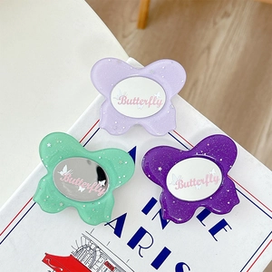 Glittery butterfly phone socket set in purple and green on a stylish book background