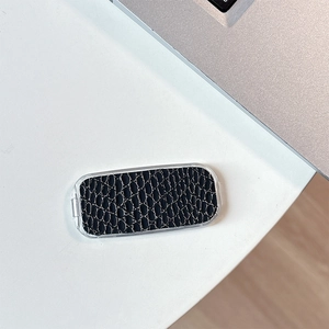 Macro detail of faux snakeskin texture on a luxury stick-on phone mirror bracket