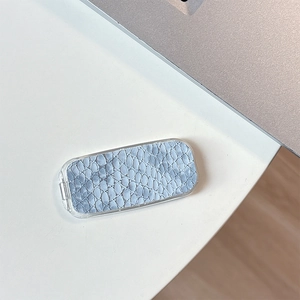 Detail of blue snakeskin pattern texture on a portable flip mirror with transparent frame