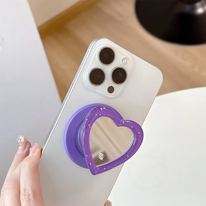 Detail shot of purple glitter heart mirror phone grip with mimi logo on a white smartphone