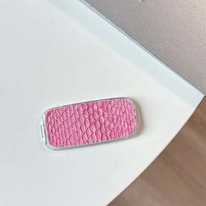 Detailed view of pink snakeskin pattern adhesive phone mirror holder on a white desk