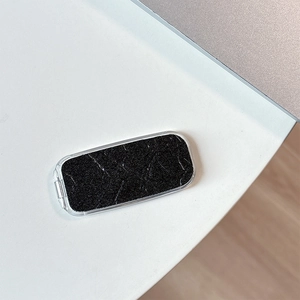 Macro shot of a rectangular phone stand with black marble pattern and smooth silver edges