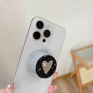 Close-up of heart mirror phone grip with sparkling rhinestones on a white smartphone
