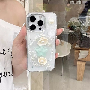 Detail of 3D sea shell and pearl decorations on a clear iPhone case with glitter