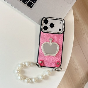 Detail of pink snake skin texture phone case with crown mirror and pearl chain strap