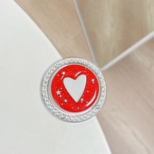 Close-up of red glitter phone grip with white heart motif and rhinestone border