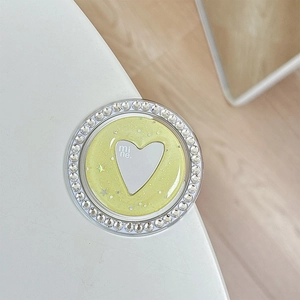Close-up of glittery heart phone grip with sparkling rhinestones and yellow finish