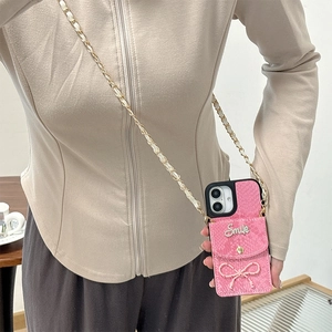Pink snakeskin phone case with a small wallet, bow tie, and detachable chain strap