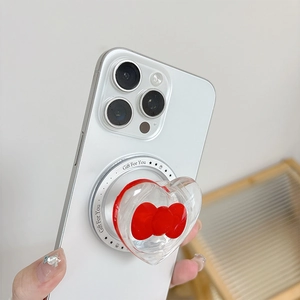 Close-up of magnetic heart phone grip with a red bow and Gift For You text on a white phone