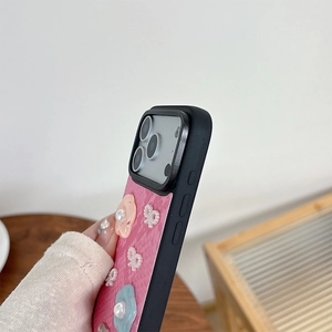 Detail of pink leather phone case featuring 3D flowers, pearl bow, and camera protection