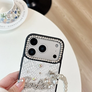 Detail of snake skin pattern iPhone case with rhinestone Barbie logo and pearl wrist strap