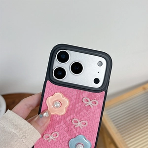 Detail of pink faux snakeskin iPhone case with 3D floral accents and pearl bow decoration