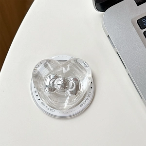 Detail of transparent heart Magsafe phone grip with a silver metallic bow decoration