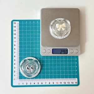 Macro shot of 29g heart phone grips with Gift For You text on a scale and cutting mat