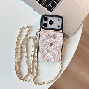 Detail of pink snakeskin iPhone case with a bowtie card holder and gold woven chain strap