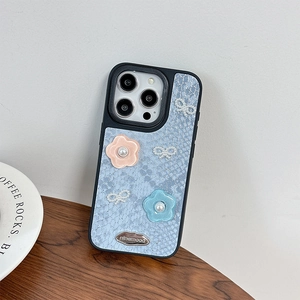 Detail of light blue snake skin texture iPhone case with 3D flowers and pearl bow accents