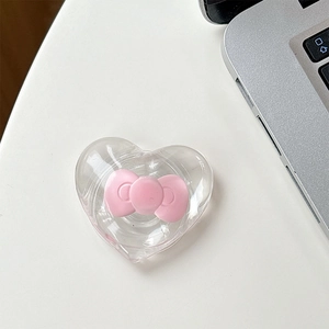 Close-up of heart-shaped magnetic phone grip with a 3D pink bow on a desk