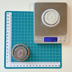 Detailansicht der MagSafe-Halterung mit 5,5 cm Durchmesser und 32,9 g auf der Waage