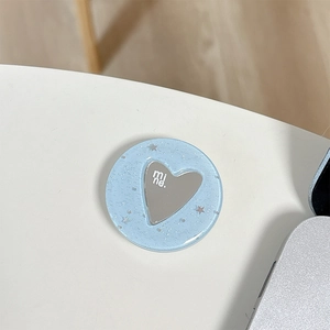 Dettaglio di un supporto per telefono glitterato blu con cuore d'argento e scritta mi ne.