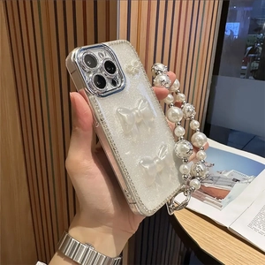 Détail d'une coque iPhone de luxe avec paillettes, nœuds en perles et chaîne étoilée