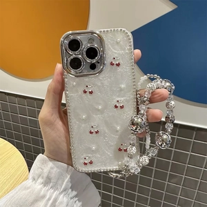 Close-up of pearl texture iPhone case with cherry motifs, rhinestones and beaded wrist strap