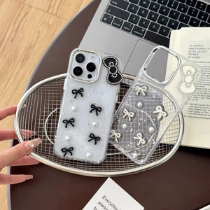 Detail view of transparent glitter phone cases with pearl bow and rhinestone star accents