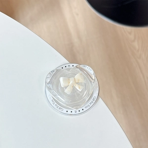 Macro view of transparent heart phone grip with cream bow on a Gift For You card