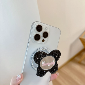 Glitter butterfly phone grip with oval mirror and rhinestone trim on a white mobile phone