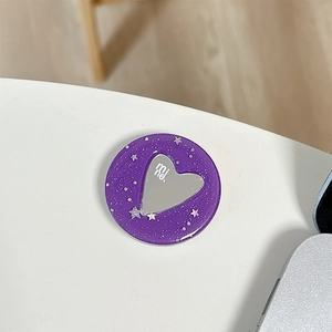 Dettaglio macro del supporto per telefono glitter viola con specchio a forma di cuore