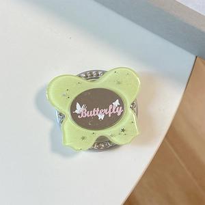 Close-up of mint green glitter butterfly phone grip with rhinestones and oval mirror