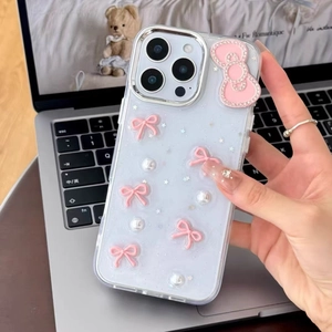 Macro detail of iPhone case with pink bow, white pearls and glitter stars decoration