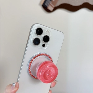 Seitenansicht des rosa Glitzer Griptok mit orangefarbenen Perlen auf weißem Handy