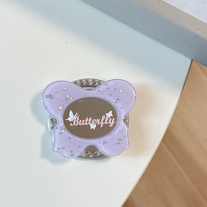 Macro detail of purple glitter butterfly phone grip with mirror and rhinestone base
