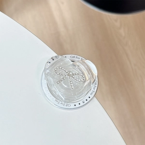 Detail showing transparent heart phone grip with sparkling diamond bow on a gift card
