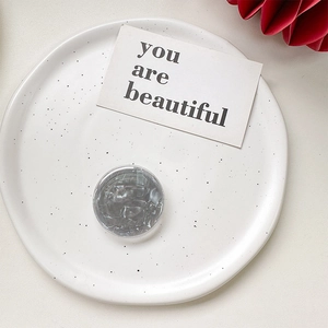 Close-up of a round marble texture phone grip holder on a stylish white ceramic tray