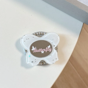 Detail of glitter butterfly phone socket with circular mirror and sparkling rhinestone base