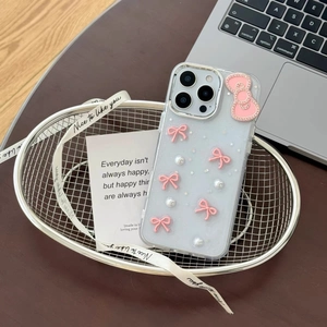 Close-up of clear blue iPhone case with 3D pink bow, pearls and glitter sequins