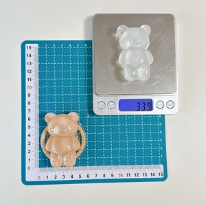 Close-up of sparkling resin bear phone grip showing dimensions and 33.9g weight