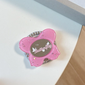 Close-up of pink glittery butterfly phone grip featuring a makeup mirror and rhinestones