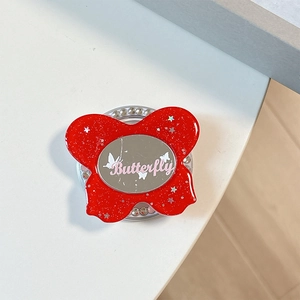 Detail of red glitter butterfly phone grip with oval mirror and crystal accents